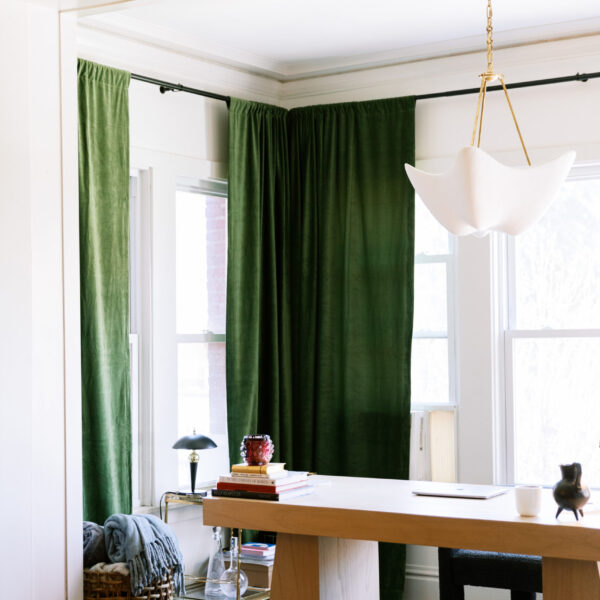 Image of desk with green curtains.
