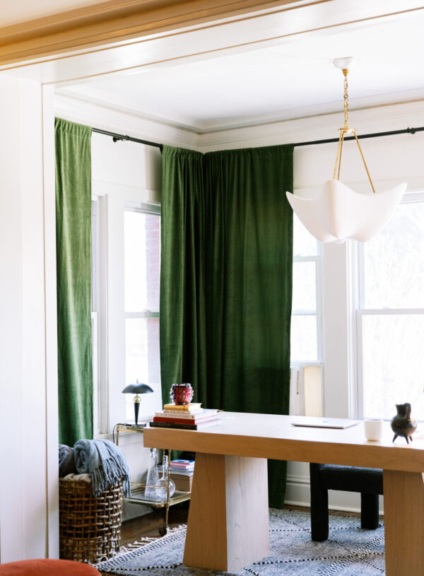 Image of desk with green curtains.